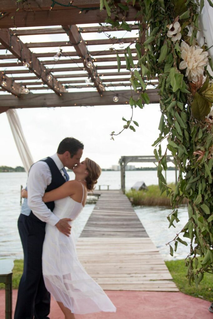 bride and groom kissing under the pergola at The Cottage on Lake Fairview
